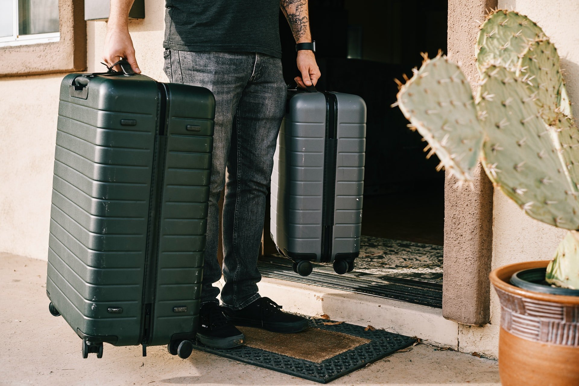 A man holding two luggage cases | Source: Unsplash